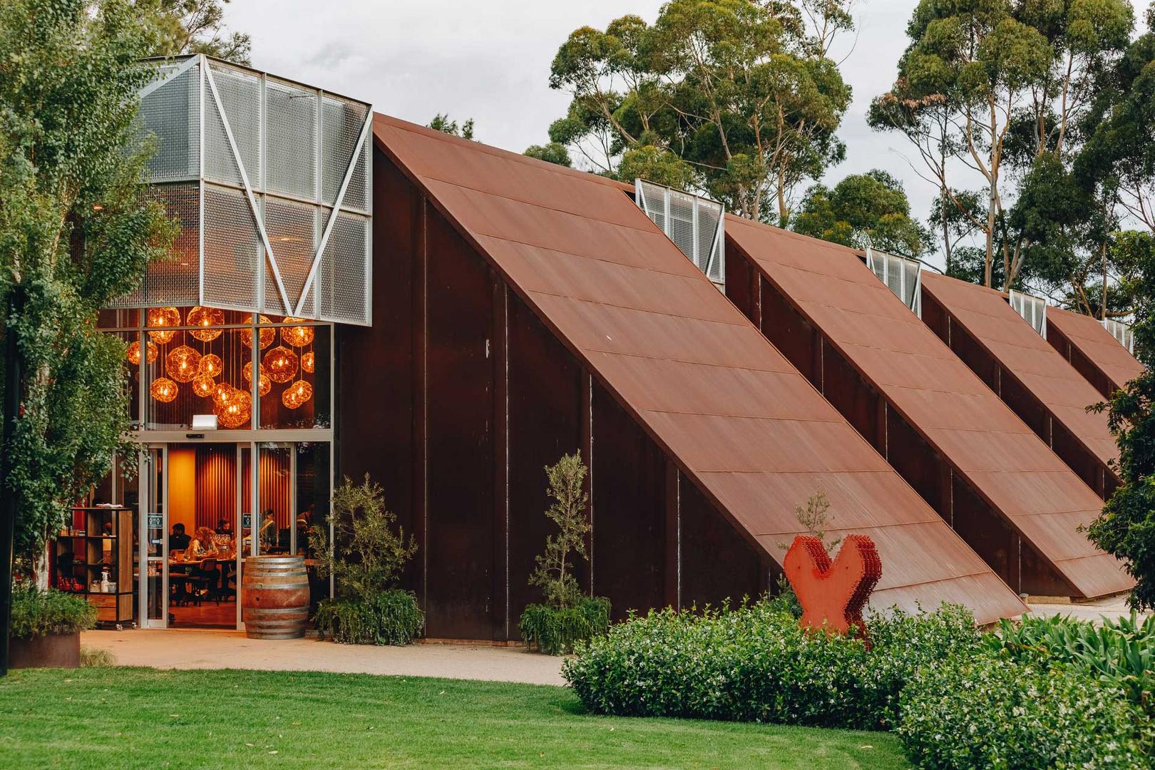 Contemporary Australian winery architecture with repeated weathered-steel roof forms